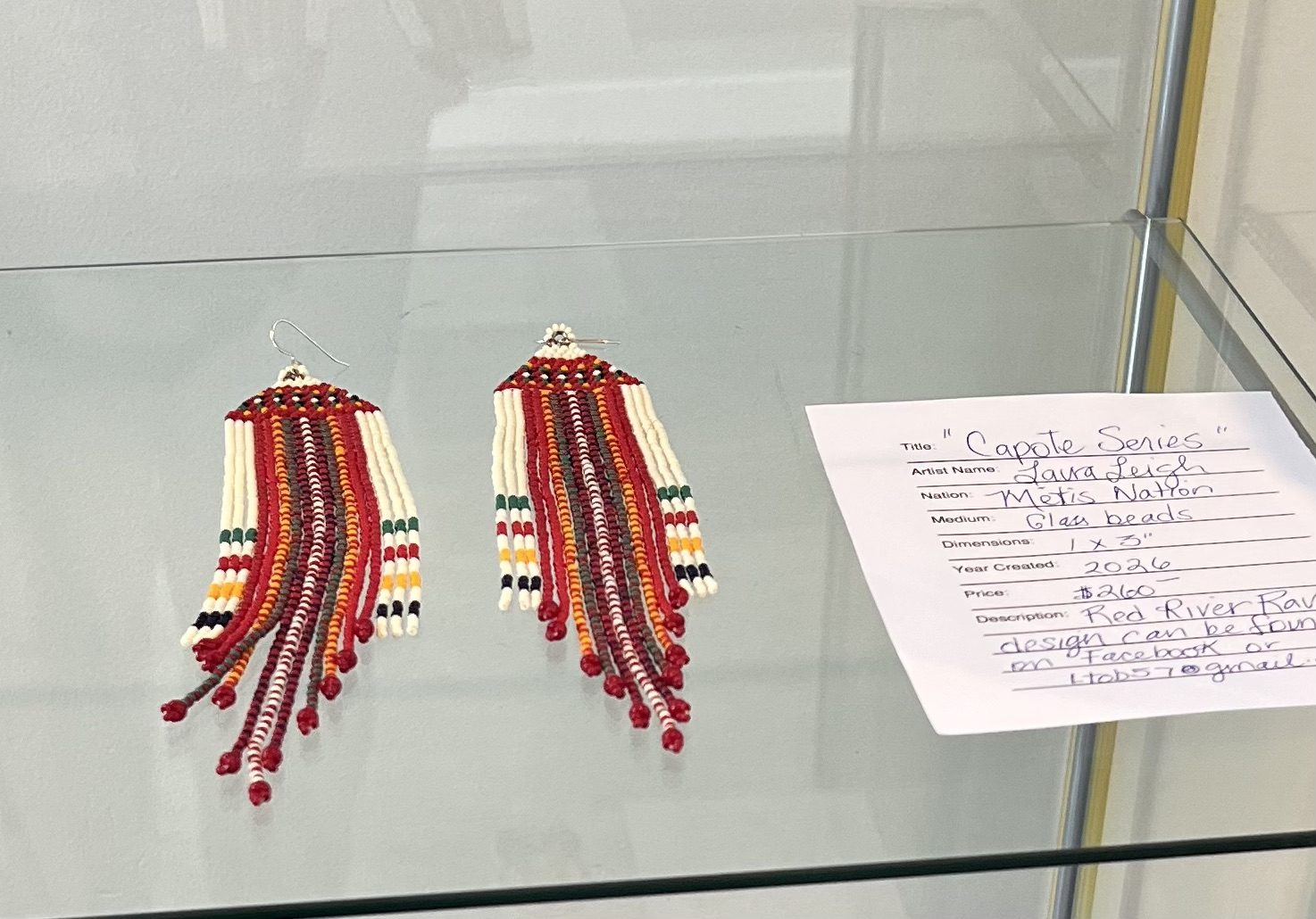 Beaded fringe earrings in a display case