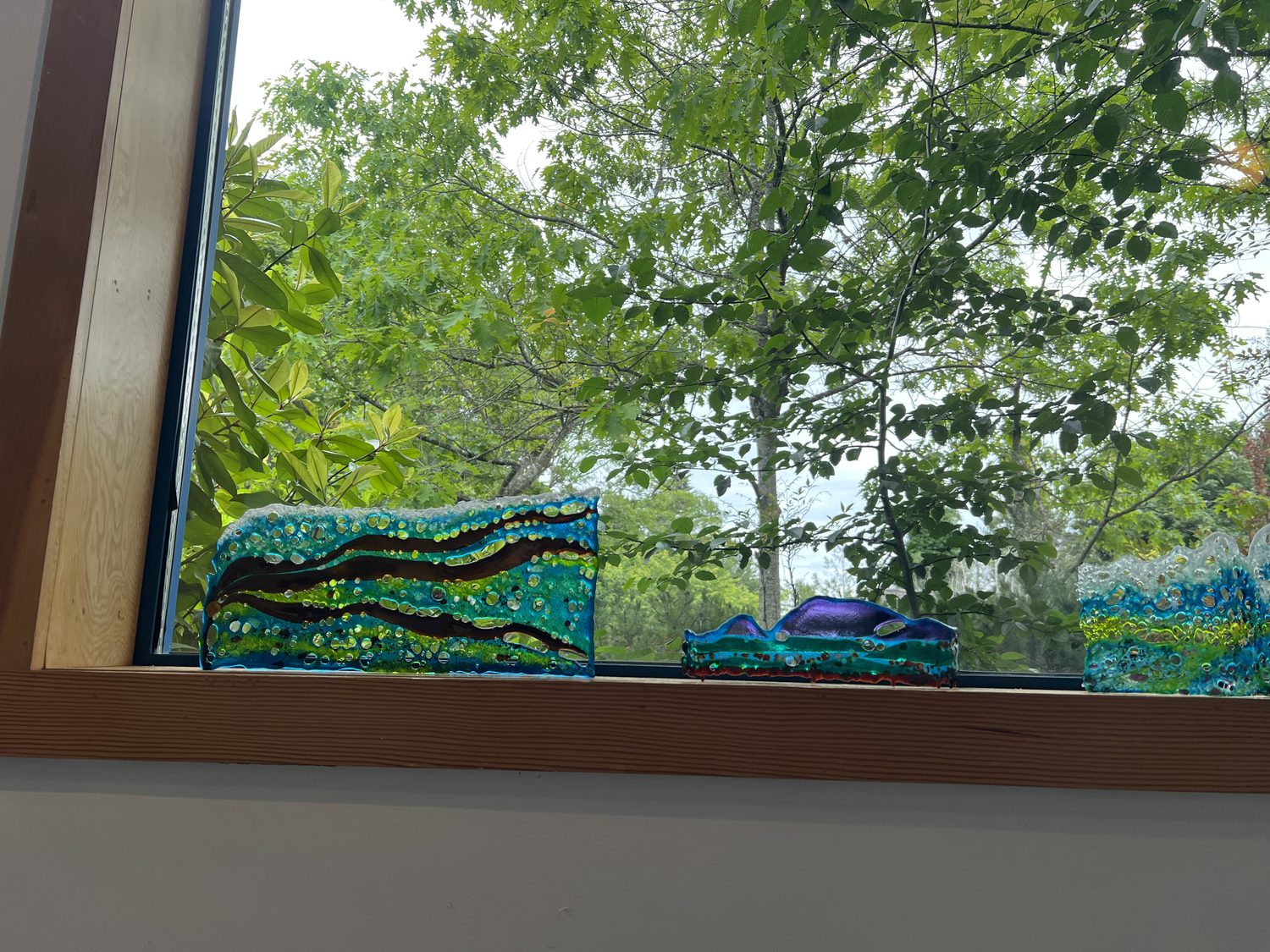Fused-glass wave sculptures on a windowsill