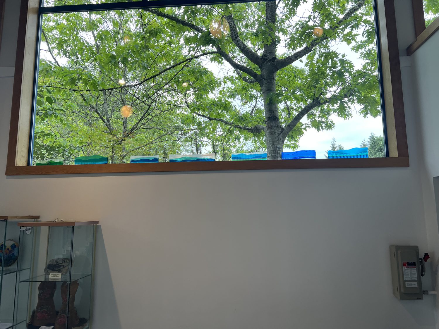 Gallery window with fused glass and a display case below