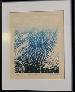 A blue linocut print of an owl