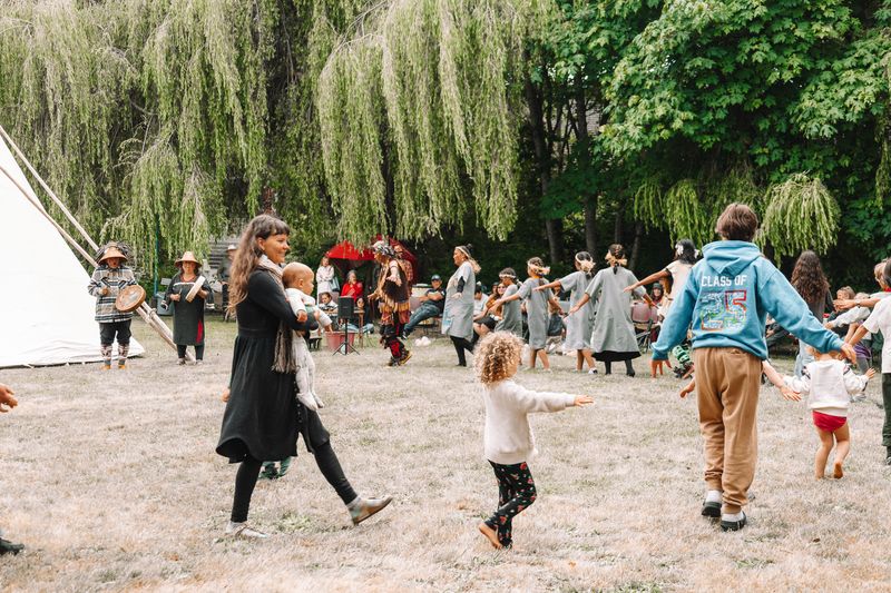 Witnesses watching the dancers perform around the tipi