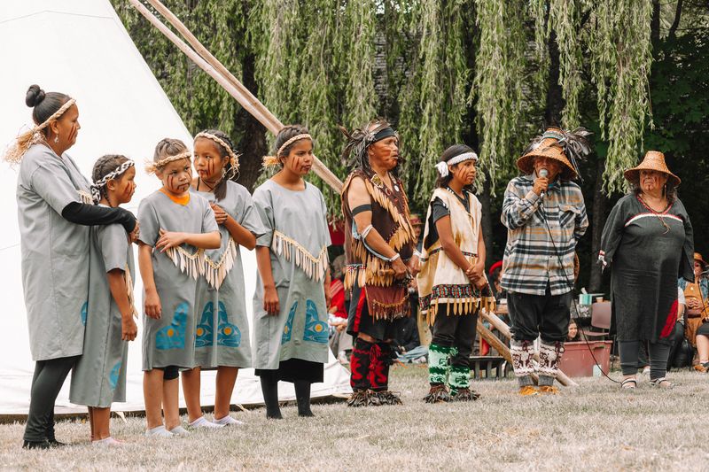Many dancers of all ages spread across the meadow led by Elders in regalia
